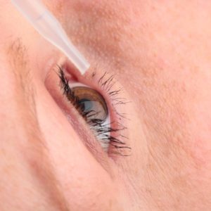 Closeup of an eye getting treatment with drops.